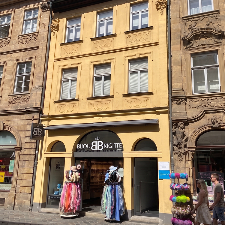 Zu sehen ist eine Mixed-use Immobilie in Bamberg (Bayern) mit einem Bijou-Brigitte-Laden und darüberliegenden Wohnungen; ein Referenzobjekt der Firma unimo real estate concepts