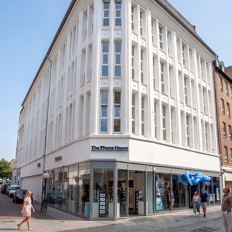 Zu sehen ist eine Mixed-use Immobilie in der Stadt Gelsenkirchen (NRW) im Baustil des weltberühmten Flatiron-Buildings aus New York, im Erdgeschoss befindet sich ein Mobilfunkgeschäft, darüberliegend sind drei Etagen Wohnraum; ein Referenzobjekt der Firma unimo real estate concepts