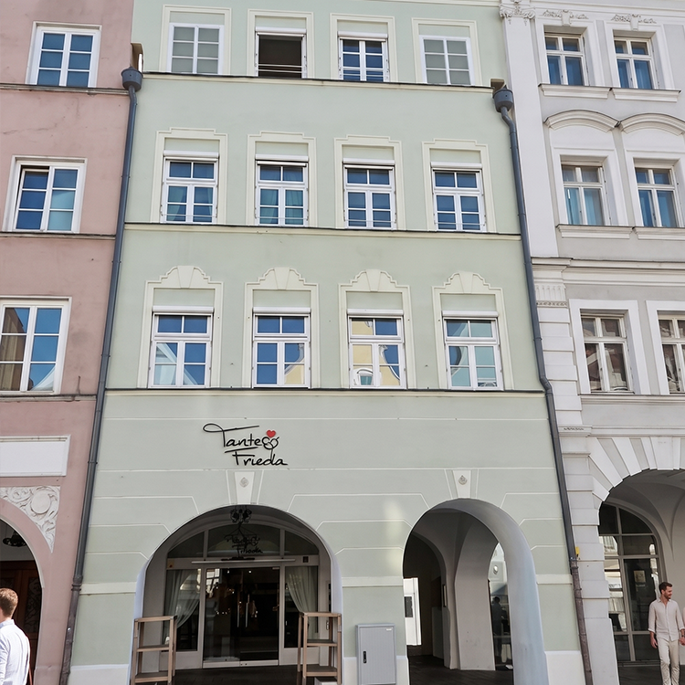 Zu sehen ist eine Mixed-use Immobilie in der Stadt Landshut (Bayern) mit Wohnungen im oberen Bereich des Hauses, das Erdgeschoss wird gastronomisch genutzt; ein Referenzobjekt der Firma unimo real estate concepts
