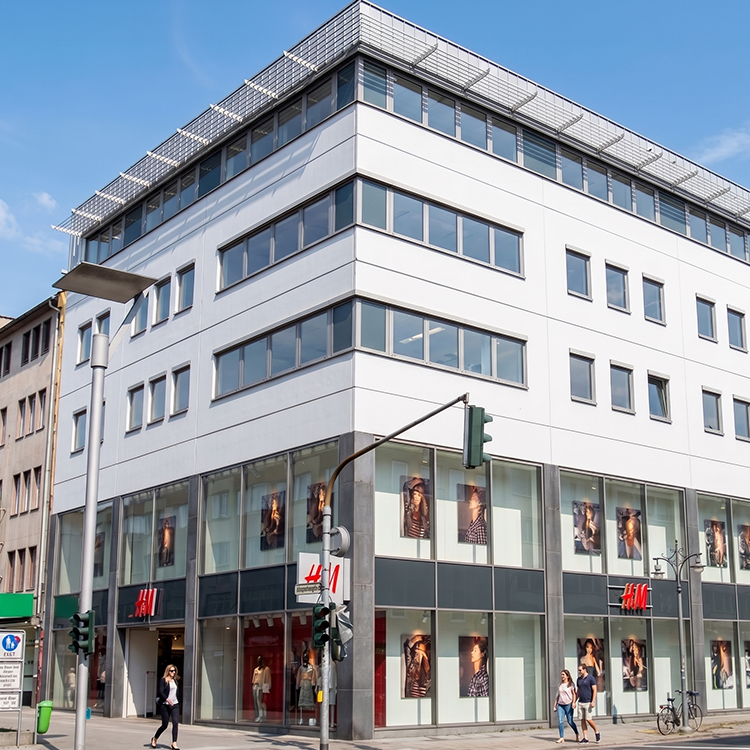 Zu sehen ist eine Mixed-use Immobilie in Mönchengladbach (NRW) mit einer H&M-Filiale sowie Büros; ein Referenzobjekt der Firma unimo real estate concepts