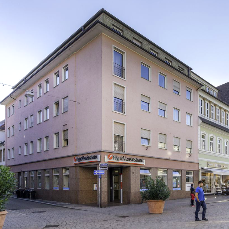 Zu sehen ist eine Mixed-use Immobilie in der Fußgängerzone in der Stadt Speyer (RP) mit einer Bank im Erdgeschoss sowie vier Etagen mit Wohnungen; ein Referenzobjekt der Firma unimo real estate concepts