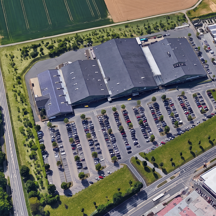 Von oben zu sehen ist ein sehr großes Nahversorgungszentrum mit großzügigen Parkmöglichkeiten in Wachtberg-Berkum (NRW); ein Referenzobjekt der Firma unimo real estate concepts